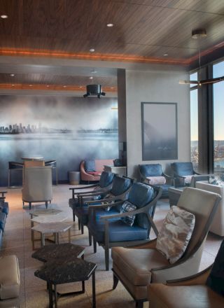 A modern lounge with comfortable seating, large windows overlooking a scenic view, and ambient lighting for a cozy atmosphere.
